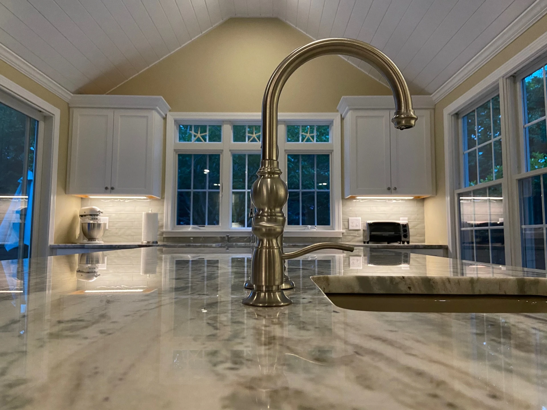 Granite island, detailed cabinetry and kitchen lighting